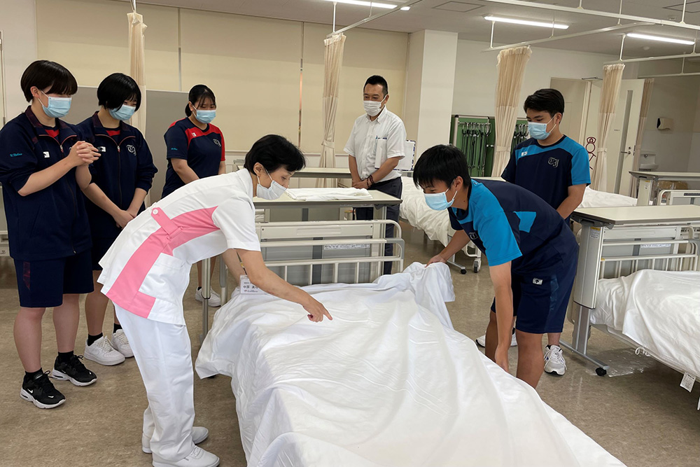 ベッドメイキングを学ぶ高校生