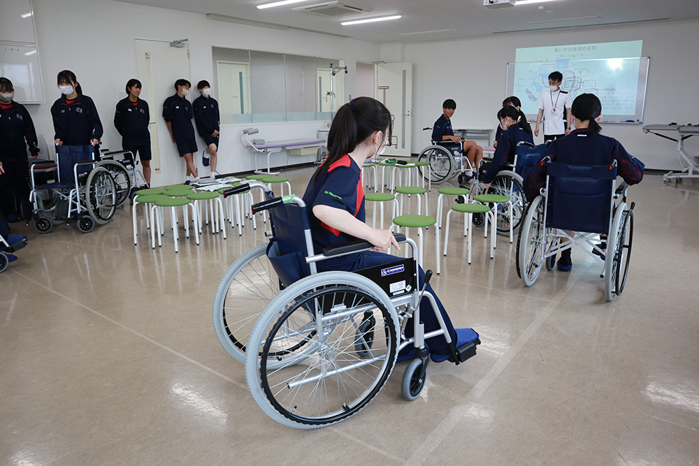 車椅子を体験する高校生
